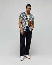 Mens Josh Jacquard Shirt, a white shirt with a black pixelated jacquard pattern featuring integrated Psycho Bunny skull logos, in a relaxed fit.
