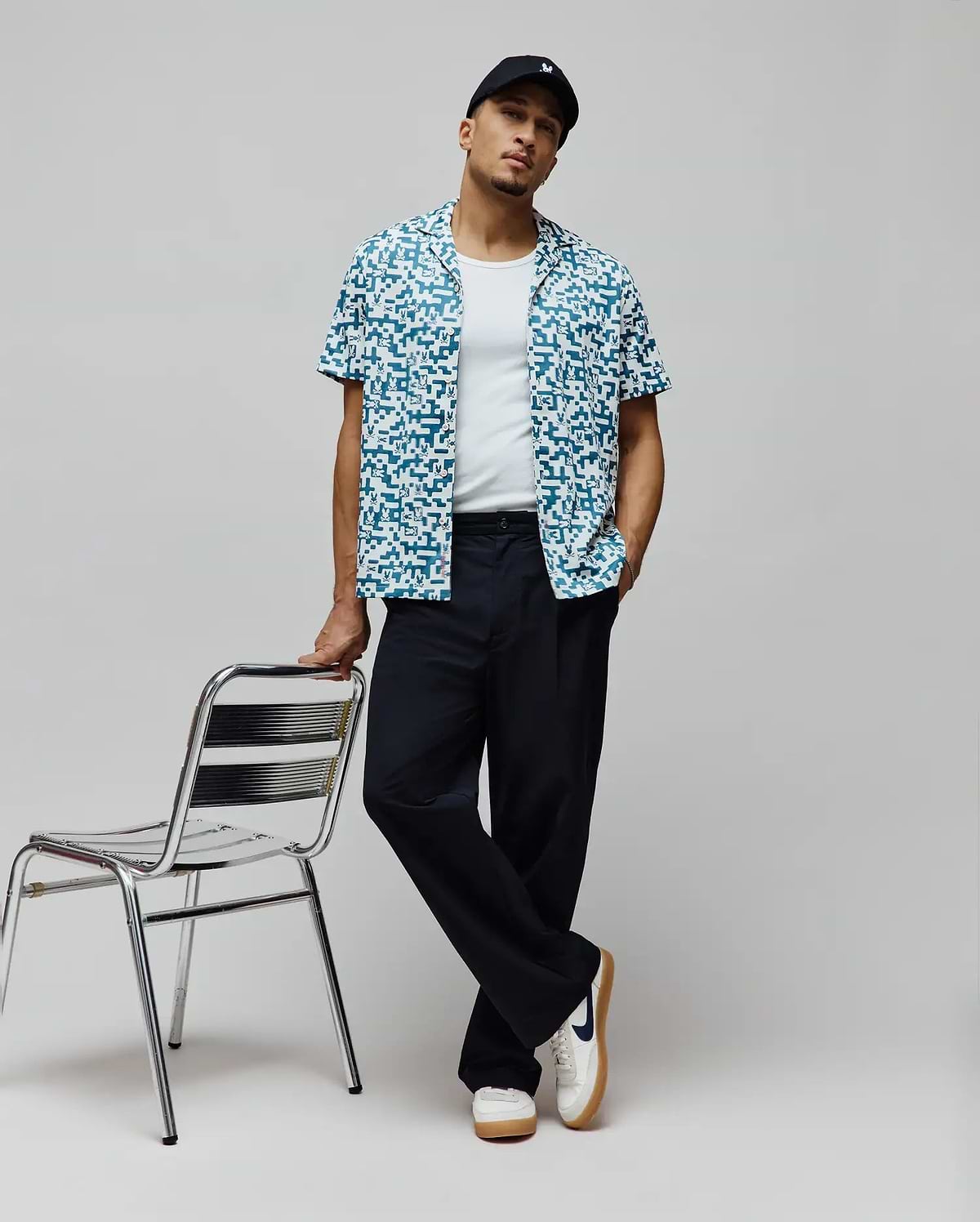 Mens Josh Jacquard Shirt, a relaxed fit short-sleeve button-up in teal and white, featuring an all-over pixelated jacquard pattern with integrated small Psycho Bunny skull logos.
