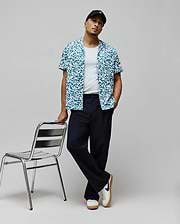 Mens Josh Jacquard Shirt, a relaxed fit short-sleeve button-up in teal and white, featuring an all-over pixelated jacquard pattern with integrated small Psycho Bunny skull logos.