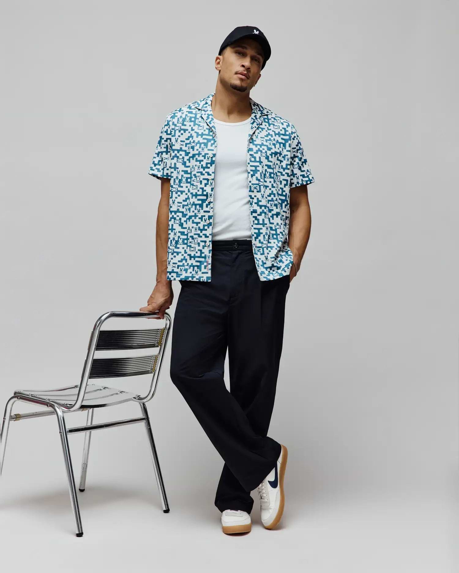 Mens Josh Jacquard Shirt, a relaxed fit short-sleeve button-up in teal and white, featuring an all-over pixelated jacquard pattern with integrated small Psycho Bunny skull logos.