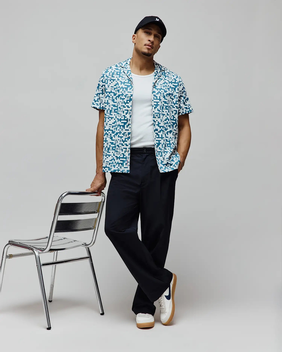 Mens Josh Jacquard Shirt, a relaxed fit short-sleeve button-up in teal and white, featuring an all-over pixelated jacquard pattern with integrated small Psycho Bunny skull logos.