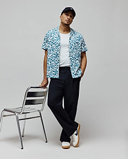 Mens Josh Jacquard Shirt, a relaxed fit short-sleeve button-up in teal and white, featuring an all-over pixelated jacquard pattern with integrated small Psycho Bunny skull logos.