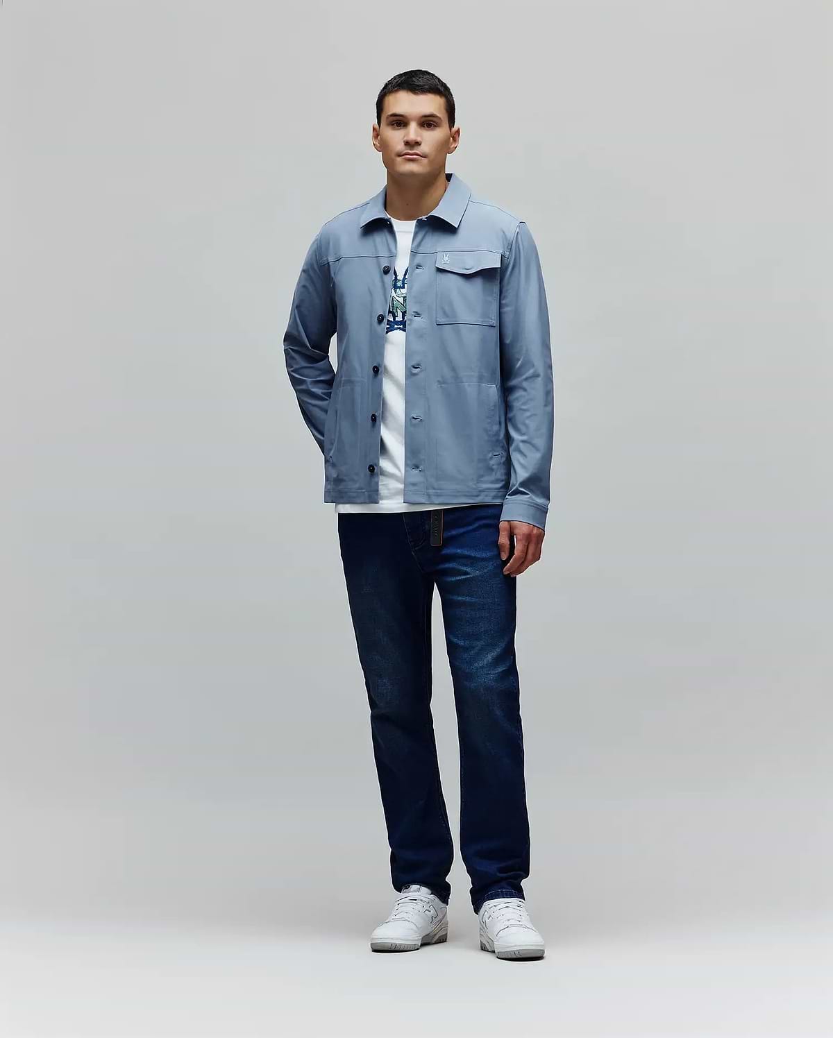 Mens Maverick Overshirt in light blue, featuring a classic fit, smooth fabric, button-front, two chest flap pockets, and a small white embroidered Psycho Bunny skull logo on the left chest. (4)