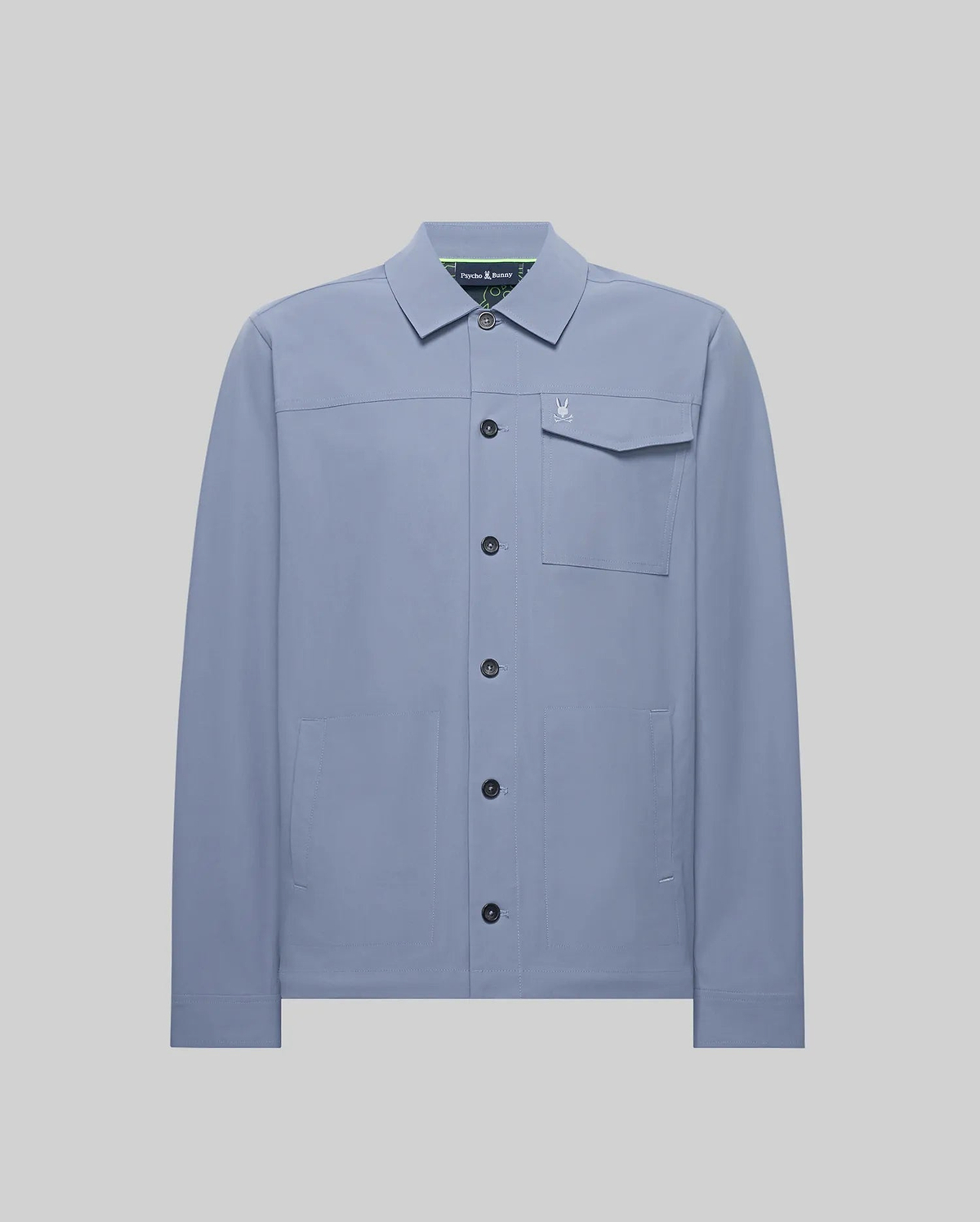 Mens Maverick Overshirt, a dusty blue collared overshirt in smooth fabric, featuring a full button-front, left chest flap pocket with a small embroidered Psycho Bunny skull logo, and two lower welt pockets. (5)