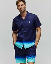 Mens Dax Tencel Shirt, a relaxed fit navy and aqua ombre short-sleeve button-up with a camp collar and small embroidered Psycho Bunny chest logo, paired with matching ombre shorts featuring a leg logo.