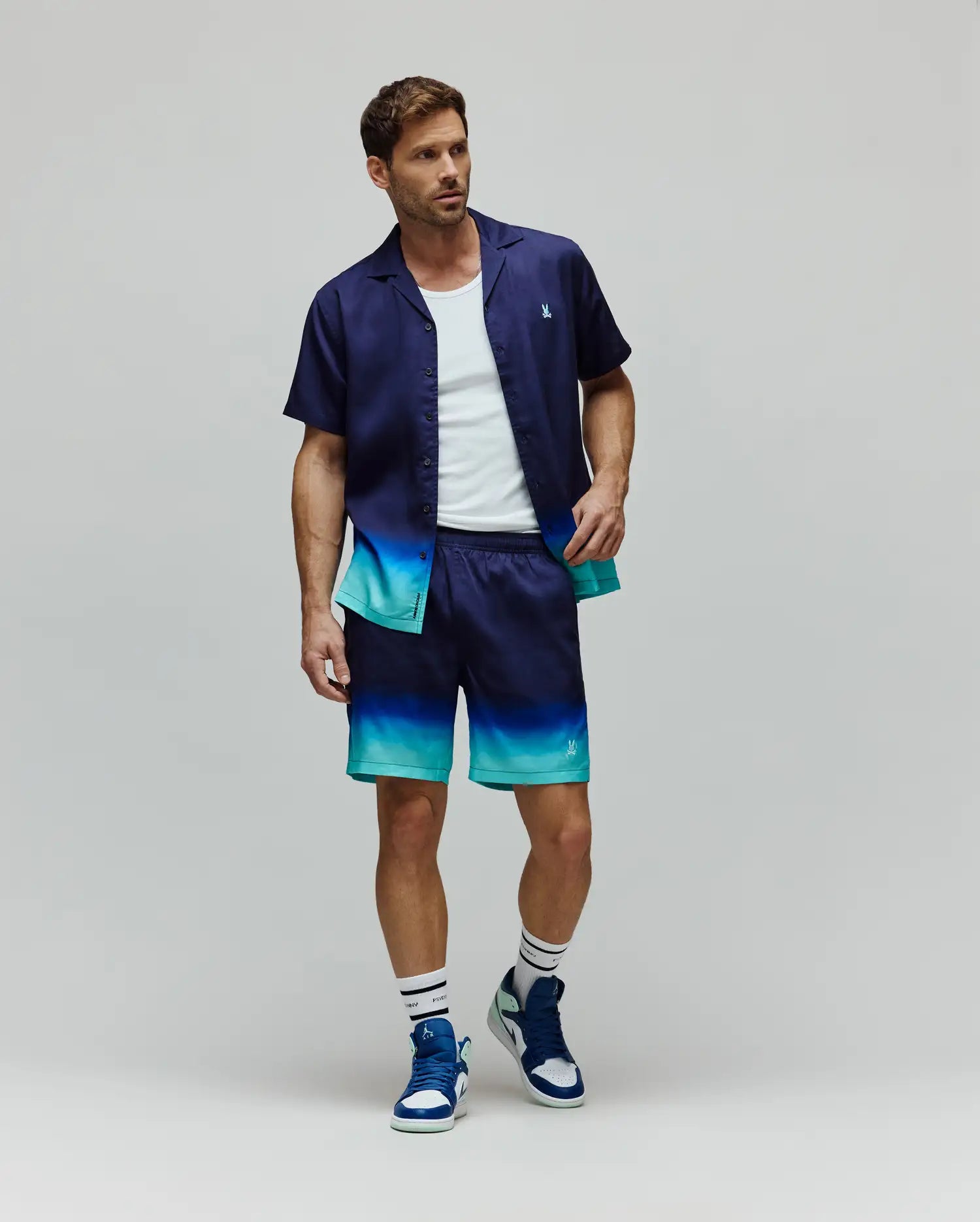 Mens Dax Tencel Shirt and matching shorts, both featuring a navy to teal ombre design, relaxed fit, smooth fabric, and small embroidered Psycho Bunny skull logos on the chest and leg.