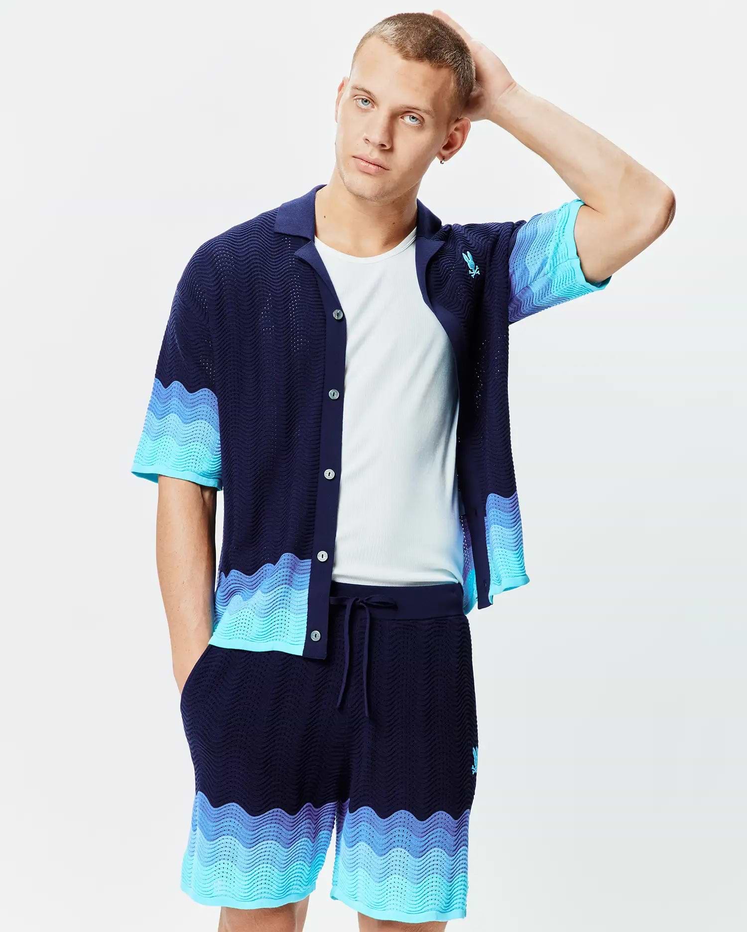 Mens Holden Oversized Knit Shirt in navy with a wavy knit texture and light blue to turquoise color block waves on sleeves and hem, featuring a small embroidered Psycho Bunny logo on the left chest.