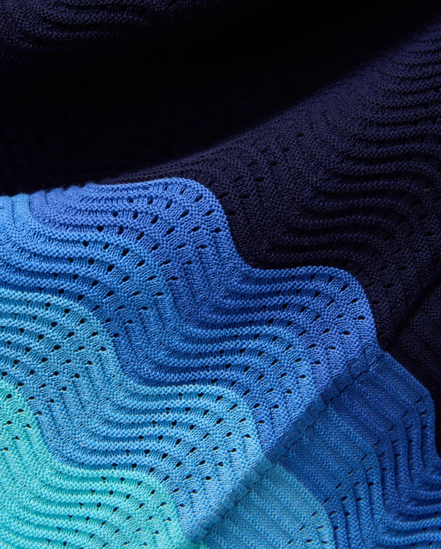 Mens Holden Oversized Knit Shirt in a wavy gradient of dark navy, medium blue, light blue, and teal, featuring an open-knit chevron pattern for a textured, breathable design.