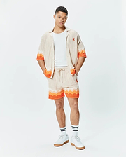 Holden Relaxed Fit Knit Shirt and matching shorts in beige textured knit with orange and white wavy stripes, featuring small embroidered orange Psycho Bunny skull logos.
