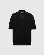 Mens Brad Oversized Knit Shirt in black, featuring a textured knit fabric, a subtle tone-on-tone Psycho Bunny skull logo on the left chest, and knit palm tree patterns.