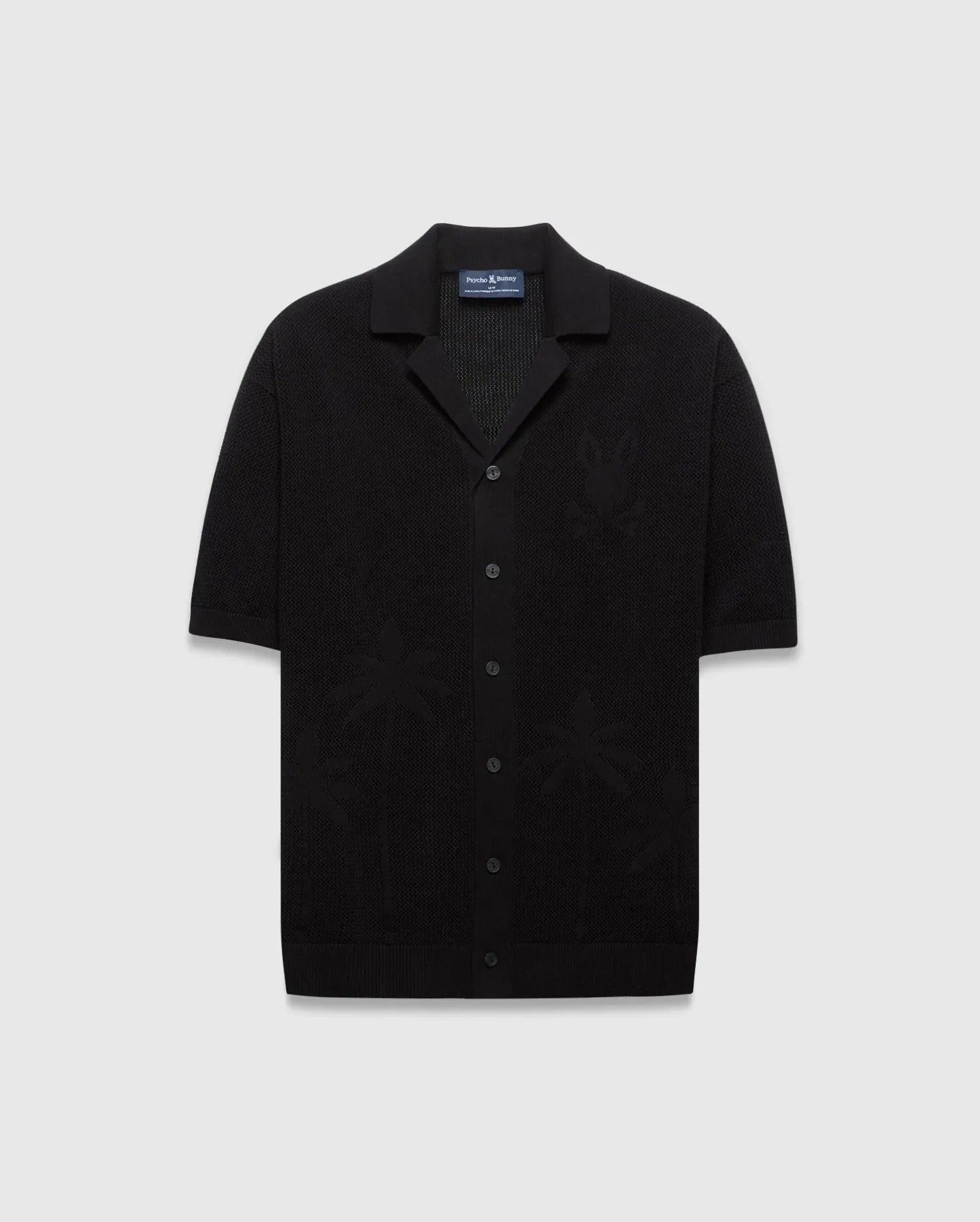 Mens Brad Oversized Knit Shirt in black, featuring a textured knit fabric, a subtle tone-on-tone Psycho Bunny skull logo on the left chest, and knit palm tree patterns.