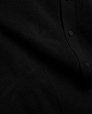 Psycho Bunny Mens Brad Oversized Knit Shirt in deep black, showcasing a unique, intricate textured knit pattern and a refined button placket with matching black buttons.