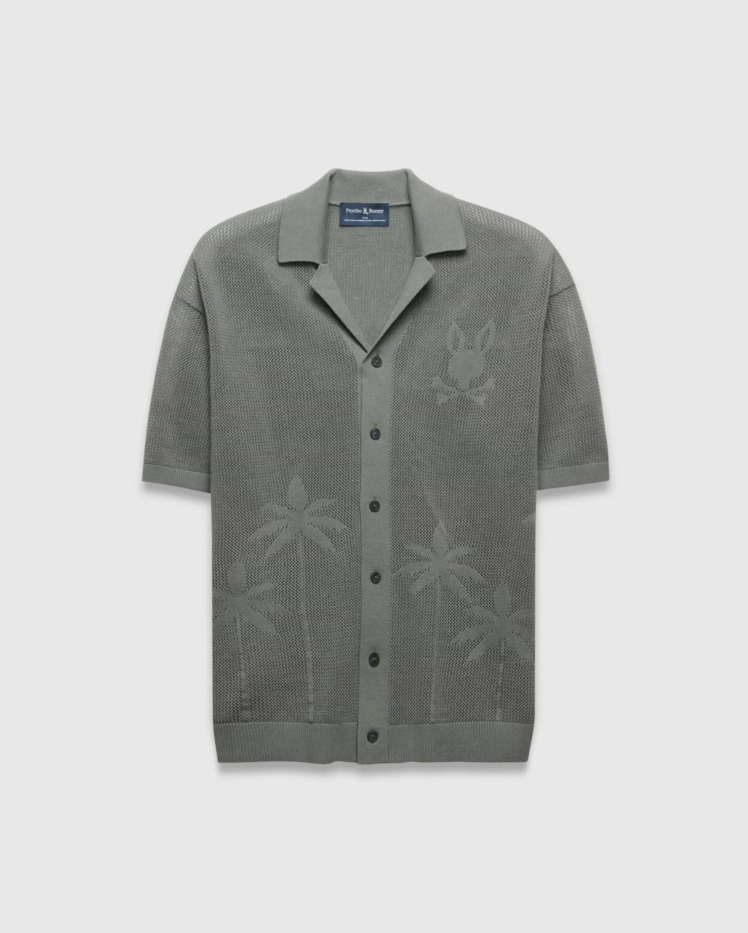 Mens Brad Oversized Knit Shirt in sage green, featuring an open knit texture, a large tonal Psycho Bunny skull logo on the left chest, and subtle palm tree patterns on the lower front.