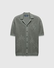 Mens Brad Oversized Knit Shirt in sage green, featuring an open knit texture, a large tonal Psycho Bunny skull logo on the left chest, and subtle palm tree patterns on the lower front.