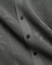 Mens Brad Oversized Knit Shirt in deep sage green, featuring a perforated openwork knit pattern, ribbed button placket, and dark branded Psycho Bunny buttons.