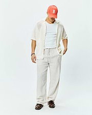 Mens Brad Oversized Knit Shirt in cream, a relaxed short-sleeve open-knit button-up, complemented by a coral Psycho Bunny skull logo baseball cap.