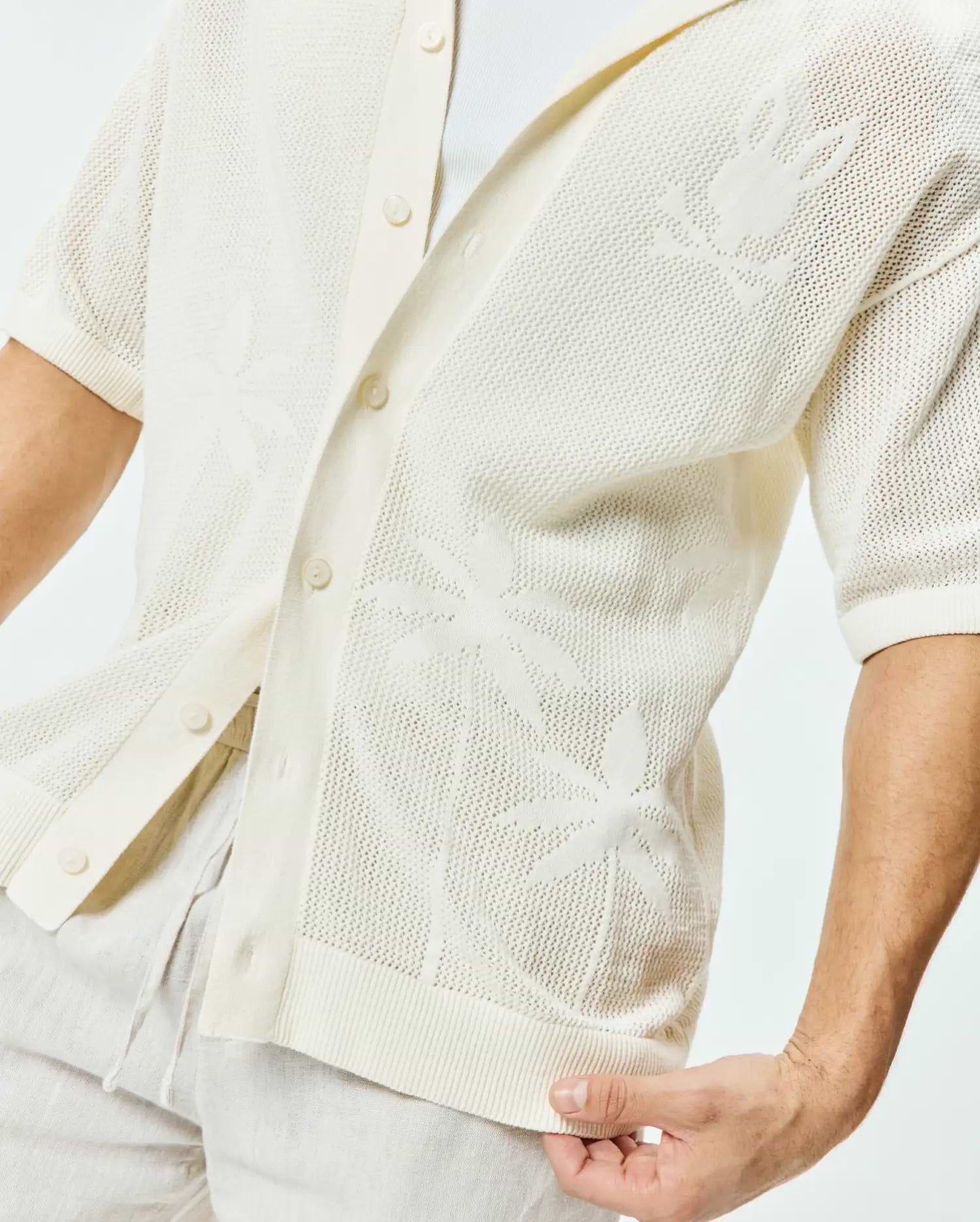 Mens Brad Oversized Knit Shirt in cream, featuring an open-knit texture with subtle palm leaf patterns and a large Psycho Bunny skull logo on the left sleeve.