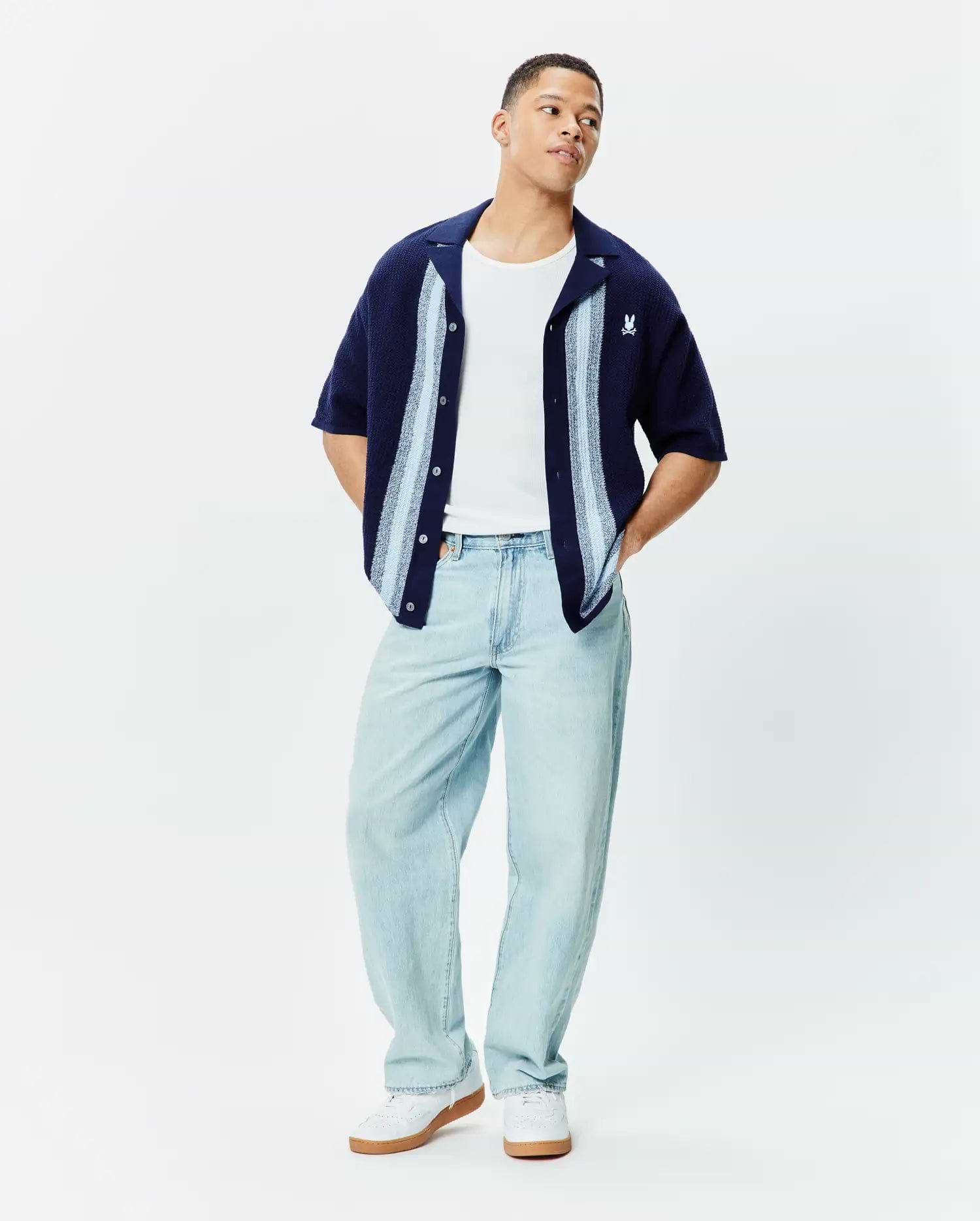 MENS GILES RELAXED FIT BORDER KNIT SHIRT in navy textured knit, featuring light blue and white vertical stripes, an open collar, and a small embroidered white Psycho Bunny skull logo on the left chest.