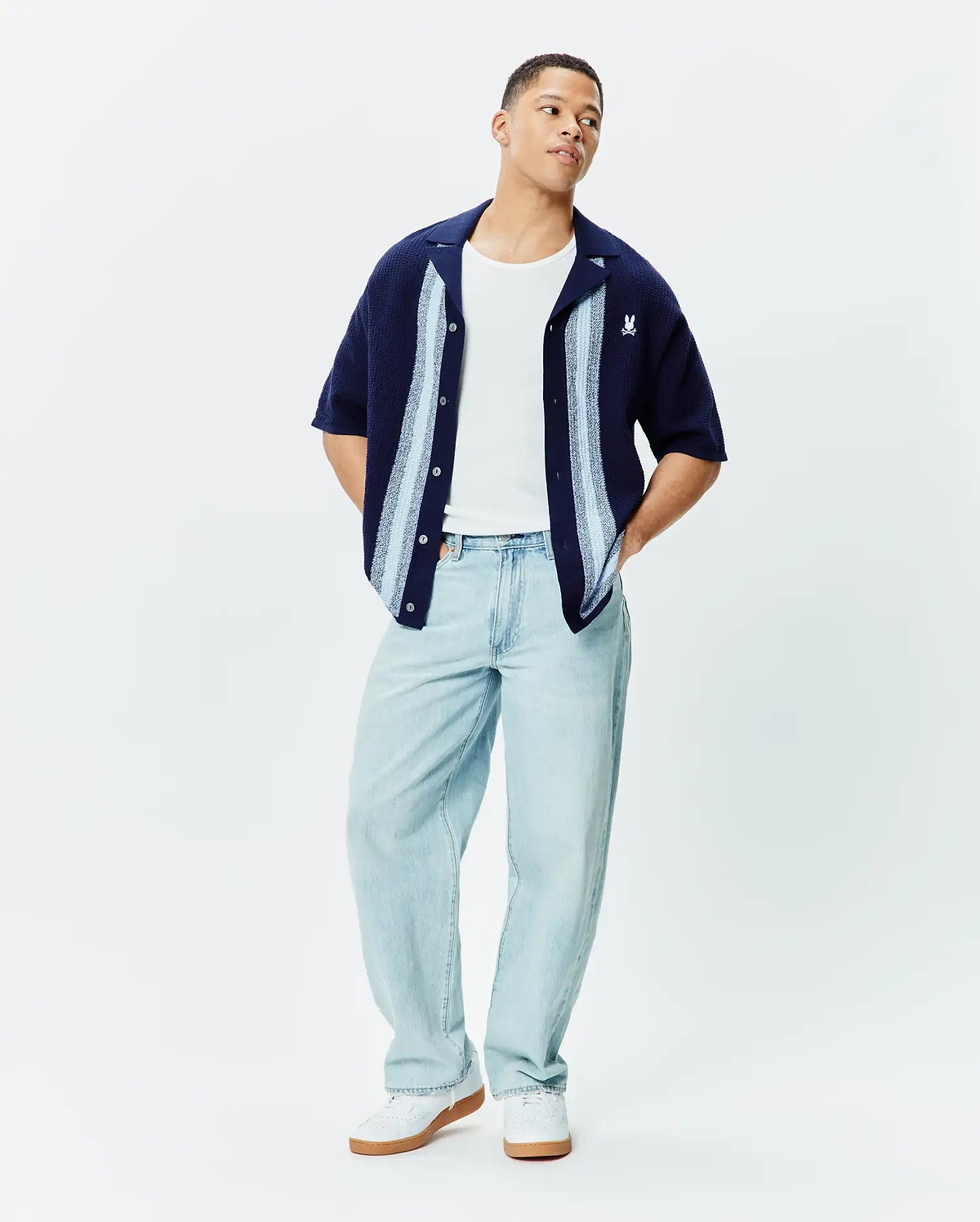 MENS GILES RELAXED FIT BORDER KNIT SHIRT in navy textured knit, featuring light blue and white vertical stripes, an open collar, and a small embroidered white Psycho Bunny skull logo on the left chest.