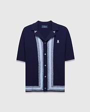 Mens Giles Relaxed Fit Border Knit Shirt in navy, featuring a textured knit, light blue and silver vertical stripes down the placket, a matching hem stripe, and a small white embroidered Psycho Bunny skull logo on the left chest.