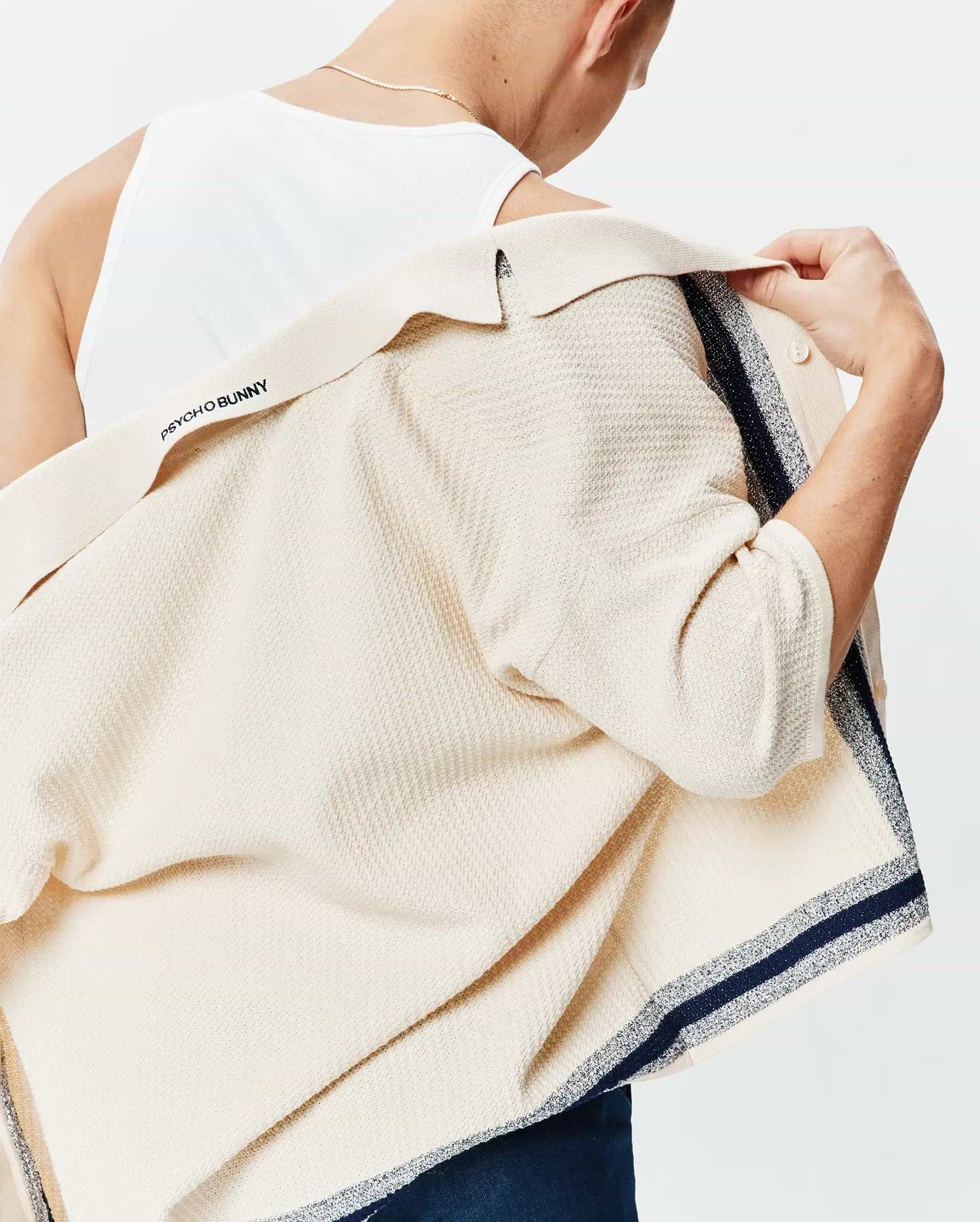 Giles Relaxed Fit Border Knit Shirt in ecru textured knit, featuring navy and silver striped borders and Psycho Bunny text on the inner collar.