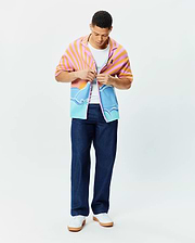 Mens Ray Relaxed Fit Jacquard Shirt featuring a vibrant pink and orange sunrise over blue ocean waves pattern, with a small embroidered Psycho Bunny skull logo on the chest.
