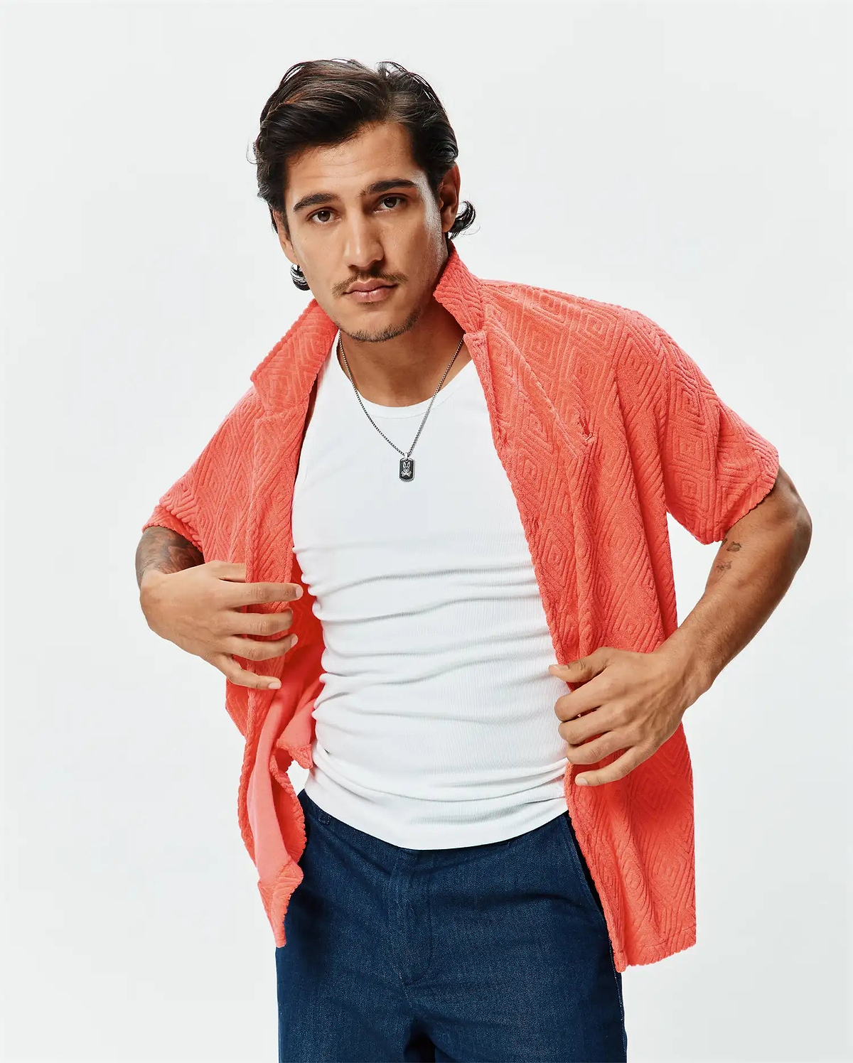 Mens Tristan Shirt: Relaxed fit coral short-sleeve shirt in textured terry fabric with a diamond pattern, featuring a small embroidered Psycho Bunny skull logo on the left chest.