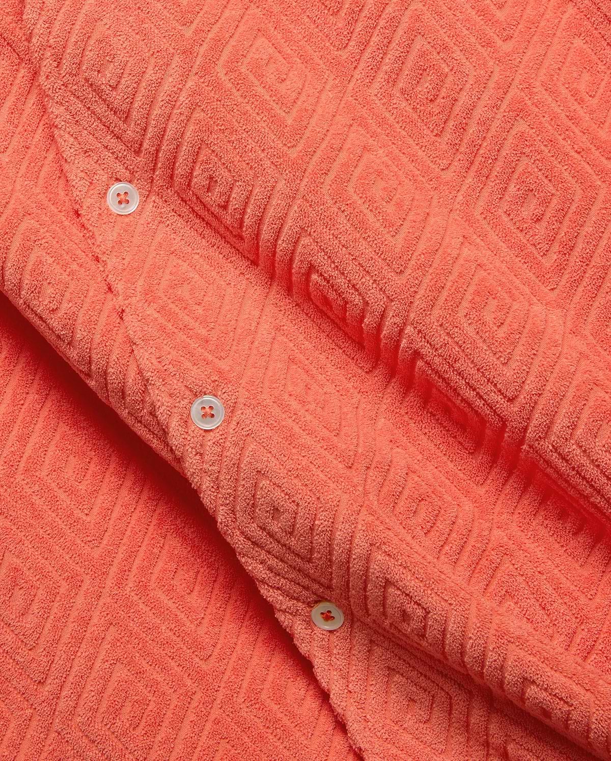 Mens Tristan Shirt, a bold coral plush terry cloth button-up featuring a distinctive raised geometric diamond pattern and contrasting white buttons.