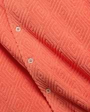 Mens Tristan Shirt, a bold coral plush terry cloth button-up featuring a distinctive raised geometric diamond pattern and contrasting white buttons.
