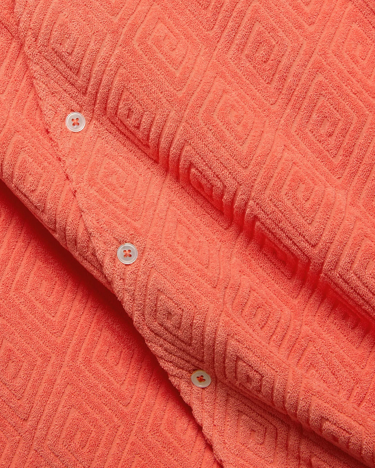 Mens Tristan Shirt, a bold coral plush terry cloth button-up featuring a distinctive raised geometric diamond pattern and contrasting white buttons.