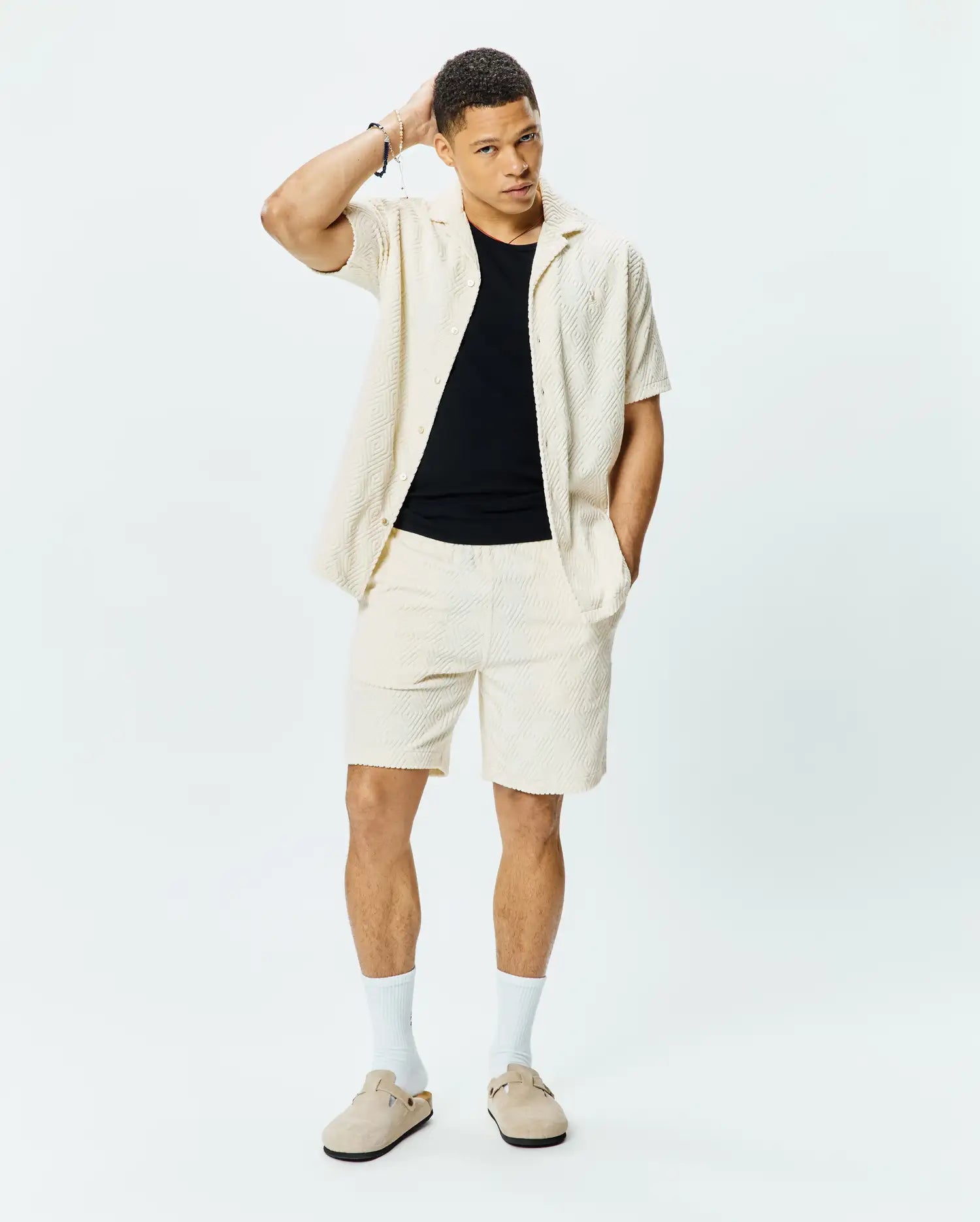 Mens Tristan Shirt. Relaxed fit cream short-sleeve shirt with an open collar and textured waffle knit geometric pattern, paired with matching cream shorts.