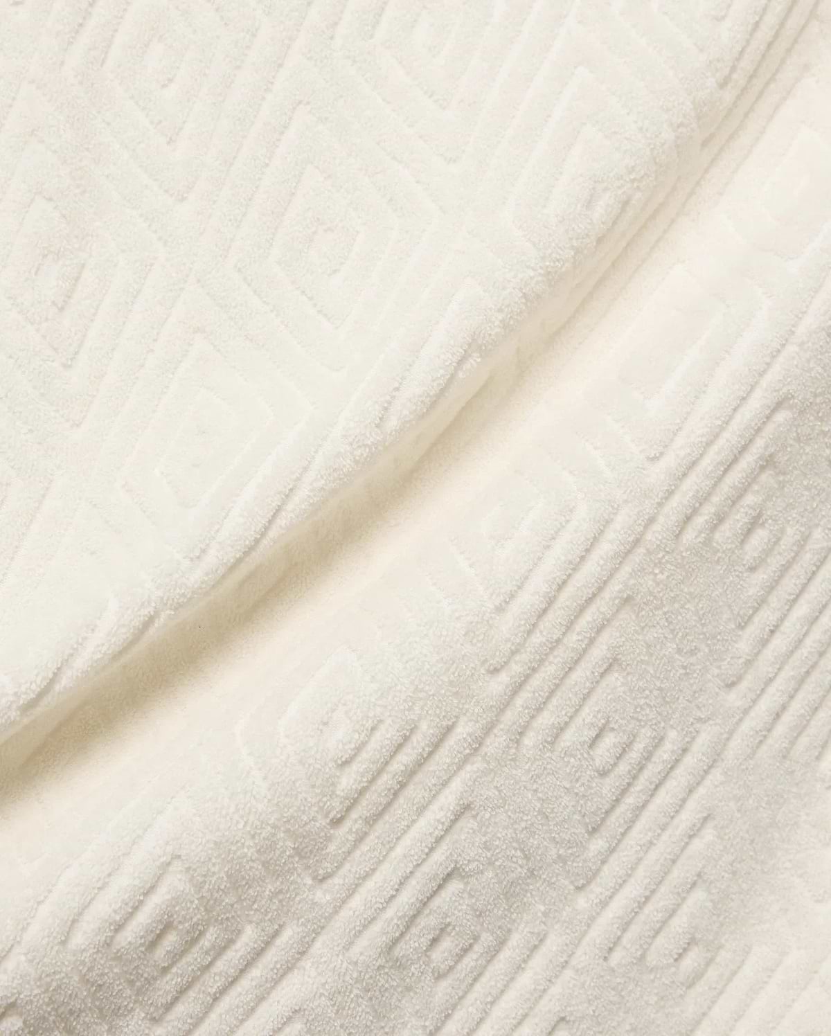 Mens Tristan Shirt in cream, a plush, textured jacquard fabric with an embossed interlocking geometric square pattern, reflecting Psycho Bunny's refined streetwear.