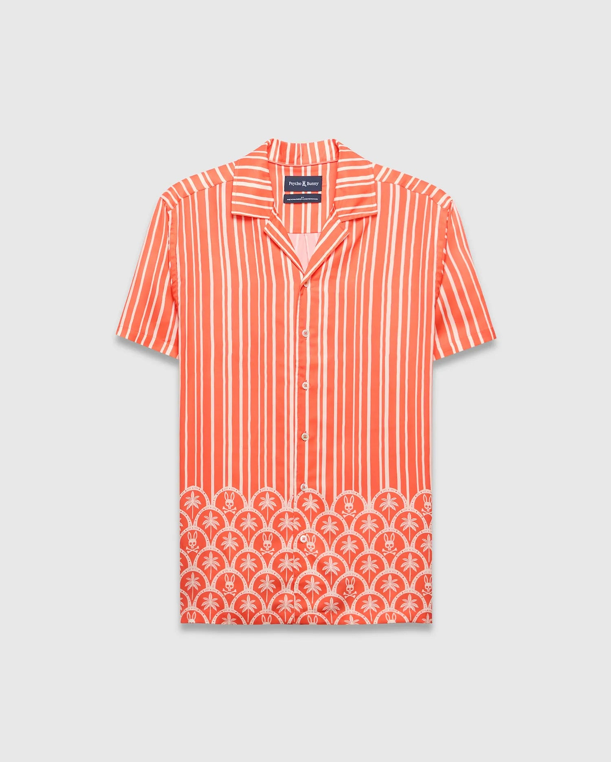 Coral orange Mens Brad Tencel Shirt, a relaxed fit camp collar shirt with white vertical stripes. The lower hem features a white scalloped pattern incorporating palm trees and small Psycho Bunny skull logos.