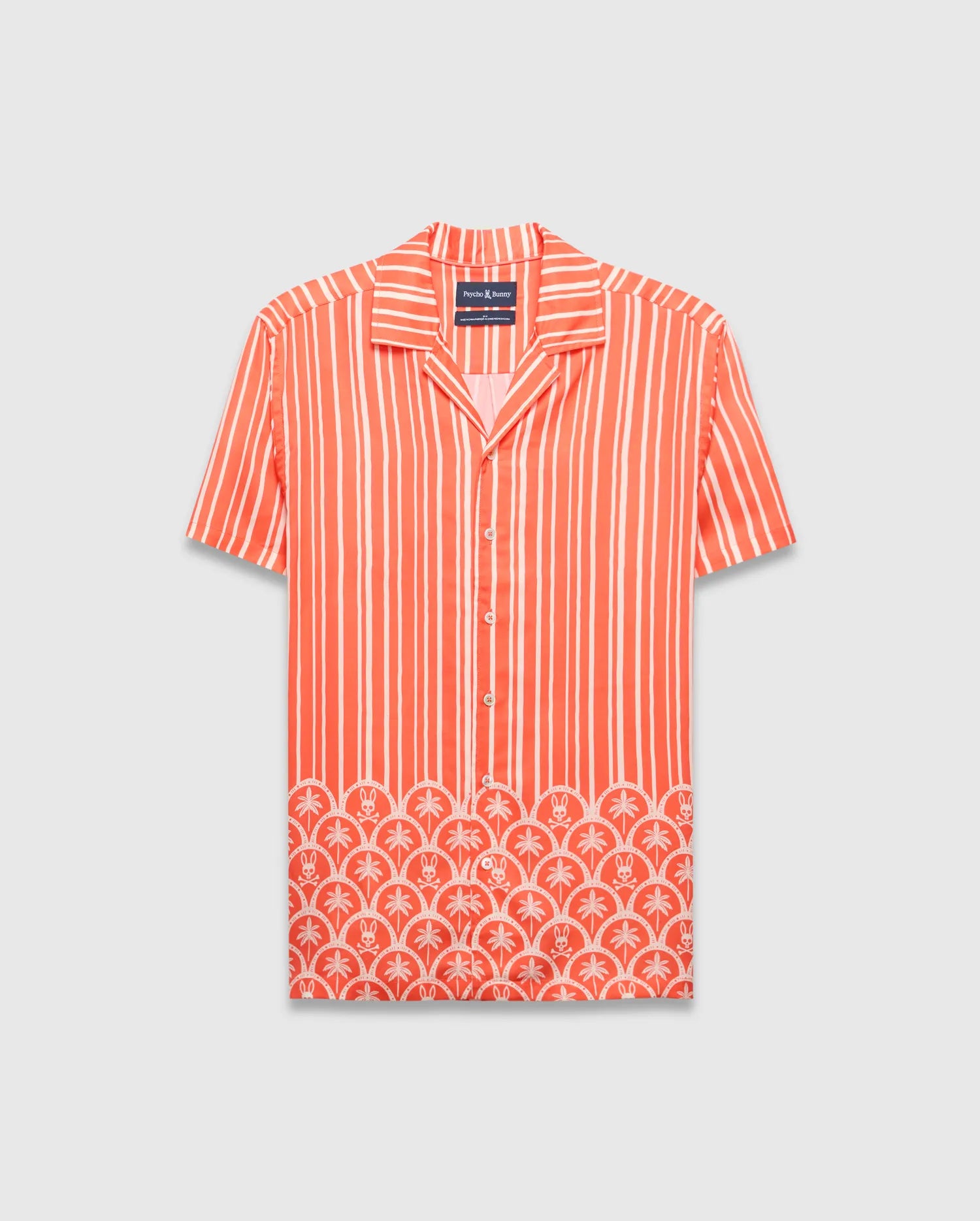 Coral orange Mens Brad Tencel Shirt, a relaxed fit camp collar shirt with white vertical stripes. The lower hem features a white scalloped pattern incorporating palm trees and small Psycho Bunny skull logos.