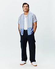 Mens Brad Tencel Shirt: Relaxed fit white short-sleeve button-up with blue vertical stripes and a unique blue and white scalloped pattern featuring small Psycho Bunny skull logos on the hem.