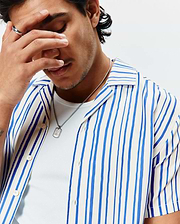 Mens Brad Tencel Shirt, a relaxed fit white camp collar shirt featuring prominent vertical blue stripes, a smooth, soft Tencel fabric, and light-colored button-front closure.
