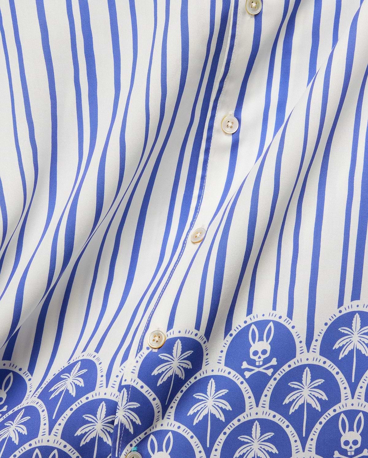Mens Brad Tencel Shirt featuring a white and royal blue vertical stripe pattern, transitioning to a decorative border with repeating palm trees and the iconic Psycho Bunny skull logo on smooth Tencel fabric.