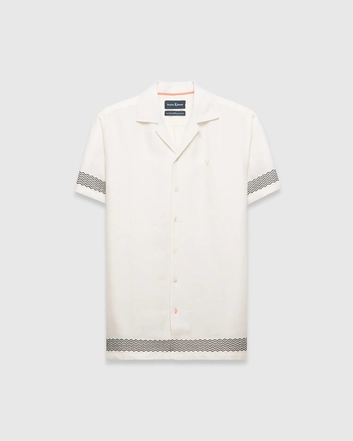 Mens Sunny Linen Shirt, an off-white relaxed linen camp collar shirt, features black zigzag patterns on sleeves and hem, an embroidered Psycho Bunny logo left chest, and orange collar trim.