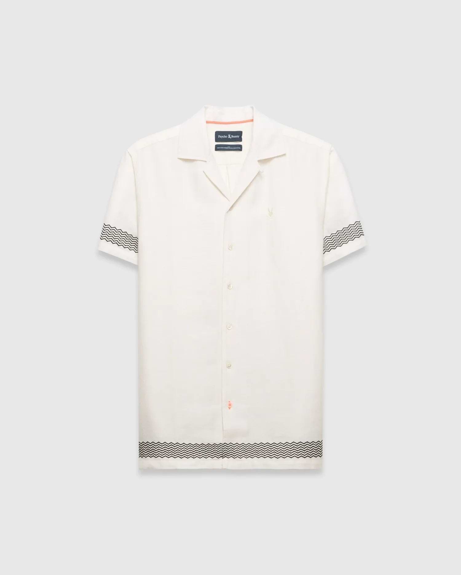 Mens Sunny Linen Shirt, an off-white relaxed linen camp collar shirt, features black zigzag patterns on sleeves and hem, an embroidered Psycho Bunny logo left chest, and orange collar trim.