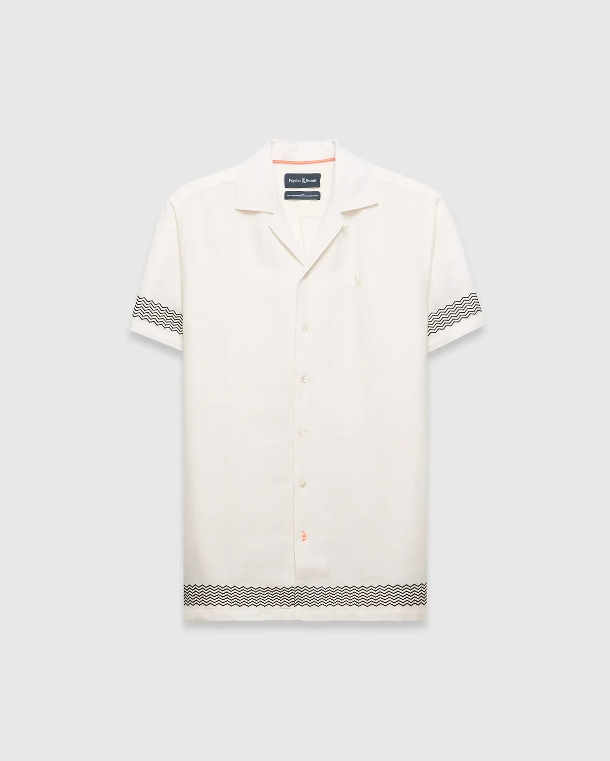 Mens Sunny Linen Shirt, an off-white relaxed linen camp collar shirt, features black zigzag patterns on sleeves and hem, an embroidered Psycho Bunny logo left chest, and orange collar trim.