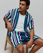 MENS CLIFF SHIRT, a relaxed fit, ribbed knit short-sleeve shirt with bold vertical stripes in teal, pink, light blue, white, and navy, featuring a small embroidered Psycho Bunny skull logo on the chest.