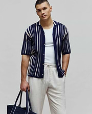 Mens Cliff Shirt, a navy blue knitted short-sleeve button-up shirt with white vertical stripes, an open collar, and a small embroidered Psycho Bunny skull logo on the left chest.
