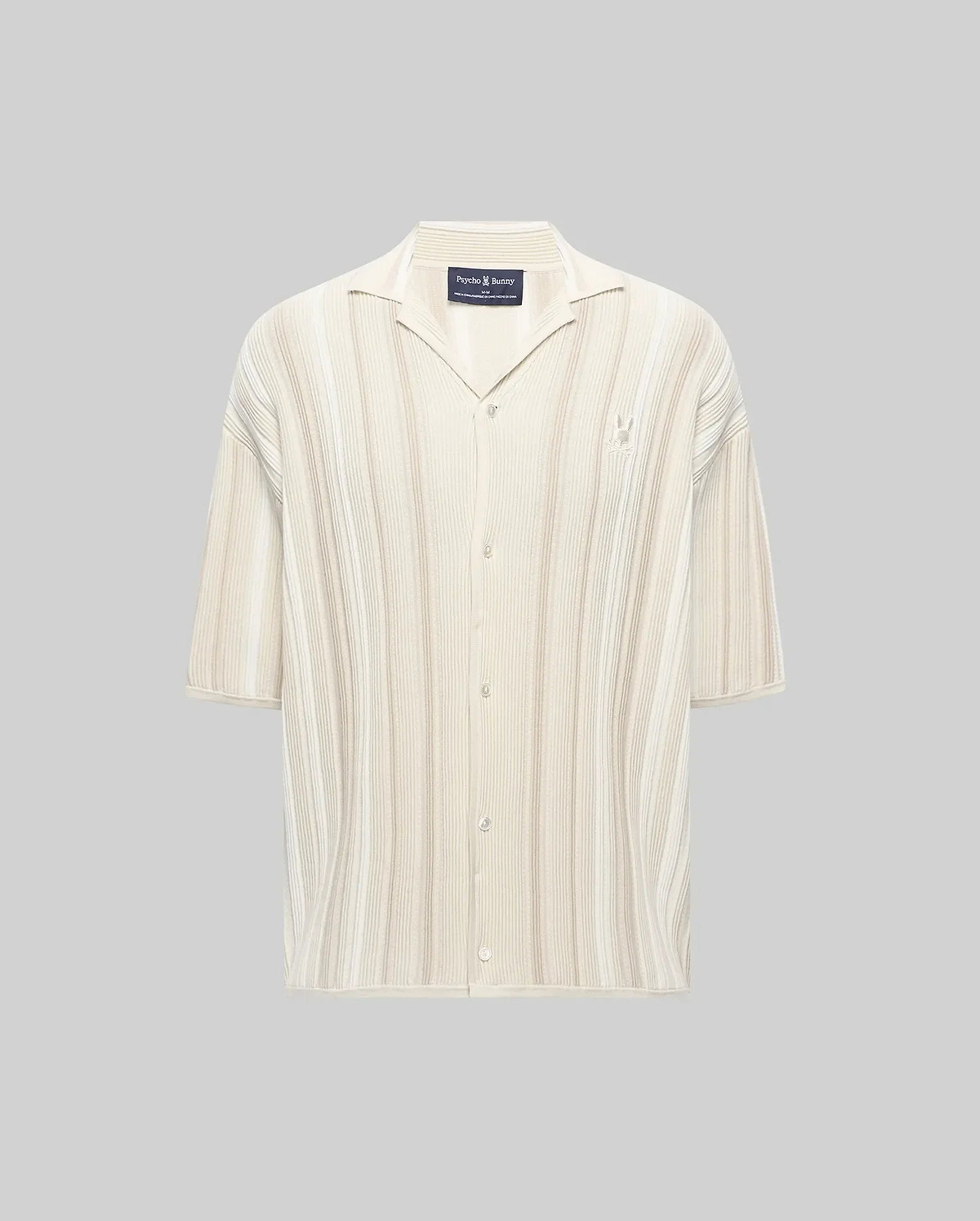 Mens Cliff Shirt, a relaxed fit cream ribbed knit short-sleeve button-up with subtle beige vertical stripes, camp collar, and small embroidered Psycho Bunny skull logo on the left chest.
