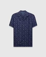 Mens Brad All Over Print Linen Blend Shirt in dark navy with a light blue repeating pattern of palm trees and small Psycho Bunny skull logos, featuring a relaxed fit and camp collar.