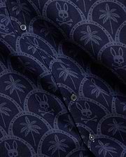 Mens Brad All Over Print Linen Blend Shirt in deep navy, featuring a lighter blue repeating pattern of palm trees and Psycho Bunny skull logos within elegant scalloped arches.