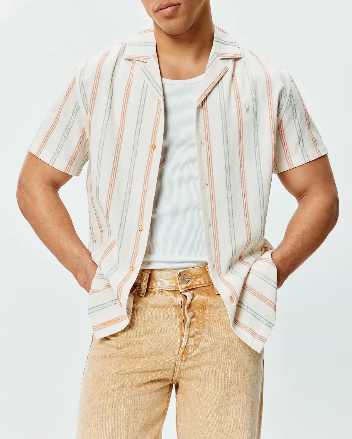 Mens Antoine Shirt, a relaxed fit cream short-sleeve button-up in textured slub fabric with vertical blue, orange, and yellow stripes, featuring a small embroidered Psycho Bunny logo on the left chest.
