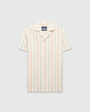 Mens Antoine Shirt: Cream short-sleeve camp collar shirt with vertical thin stripes in light blue, peach, and yellow, featuring a small embroidered Psycho Bunny skull logo on the left chest and a relaxed fit.