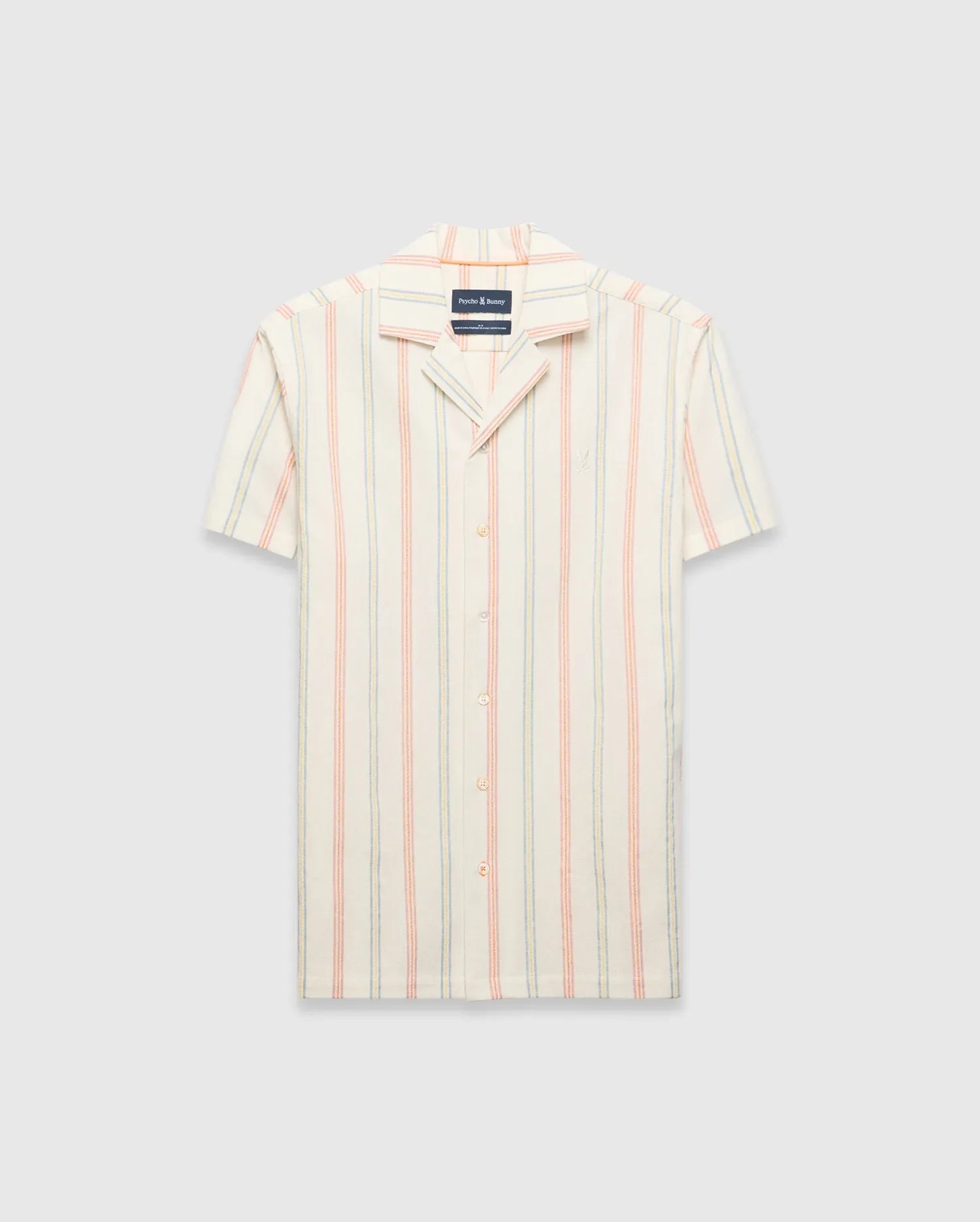 Mens Antoine Shirt: Cream short-sleeve camp collar shirt with vertical thin stripes in light blue, peach, and yellow, featuring a small embroidered Psycho Bunny skull logo on the left chest and a relaxed fit.