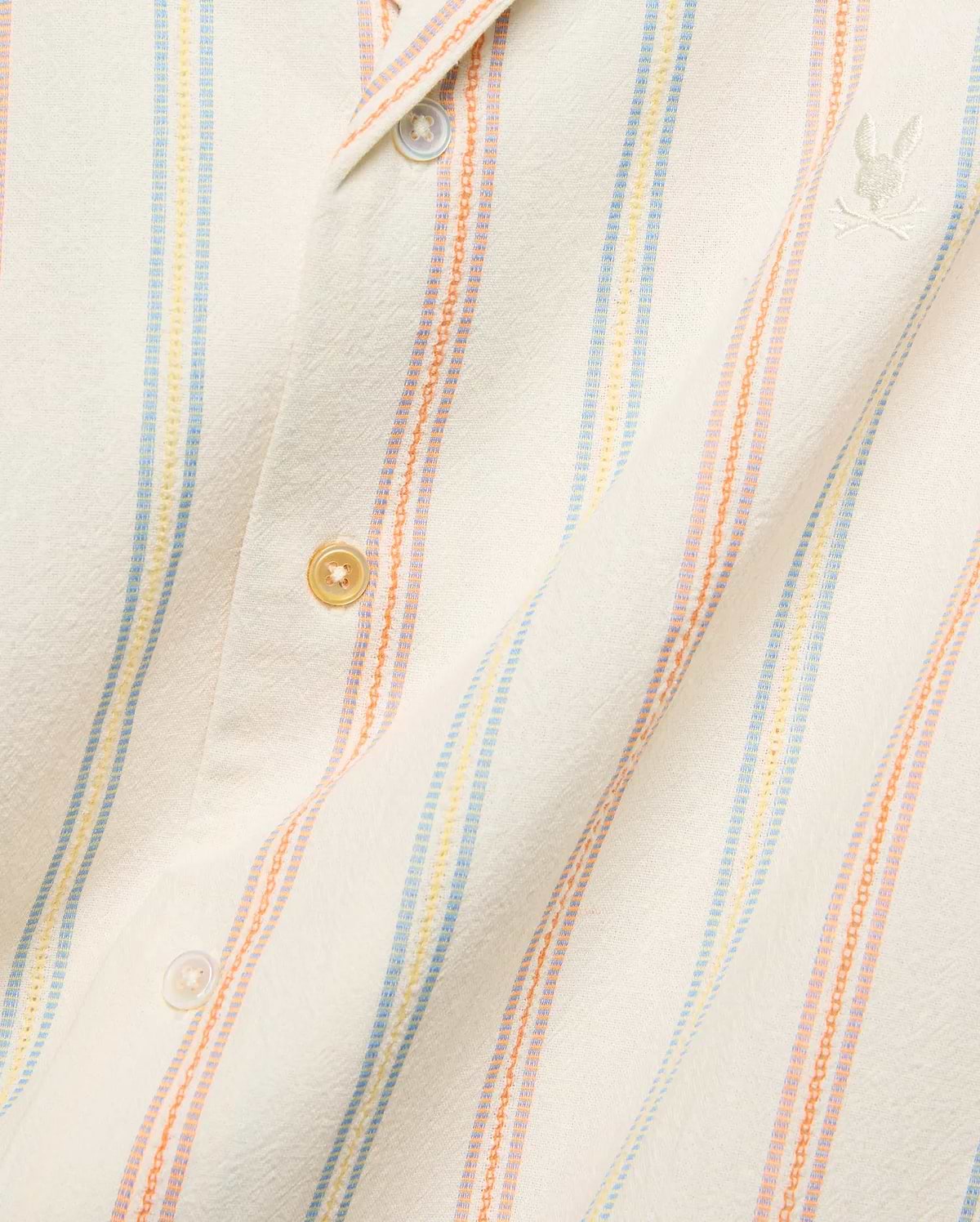 Mens Antoine Shirt, a cream textured woven shirt with vertical light blue, yellow, and orange stripes, featuring a small embroidered Psycho Bunny skull logo on the left chest.