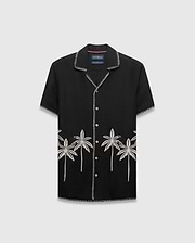 Mens Brad Linen Shirt, a black relaxed-fit camp collar shirt with white contrast stitching, embroidered light grey palm trees, and a small black Psycho Bunny skull logo.